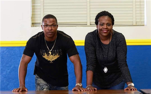 Tee Jay Wilson on left, Ivi McDaniel on right looking into the camera with their hands on a table.